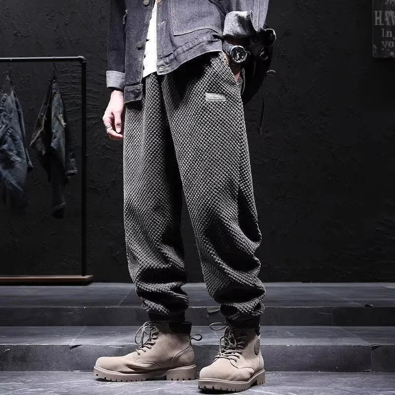 Men's grey ankle-tied straight-leg sweatpants laid flat, showing non-ironing casual design.
