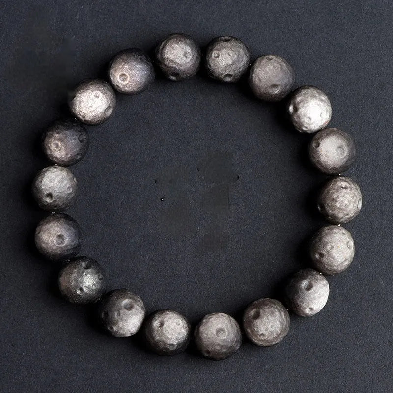Natural obsidian crater ball bracelet showing distinctive grinding texture on beads