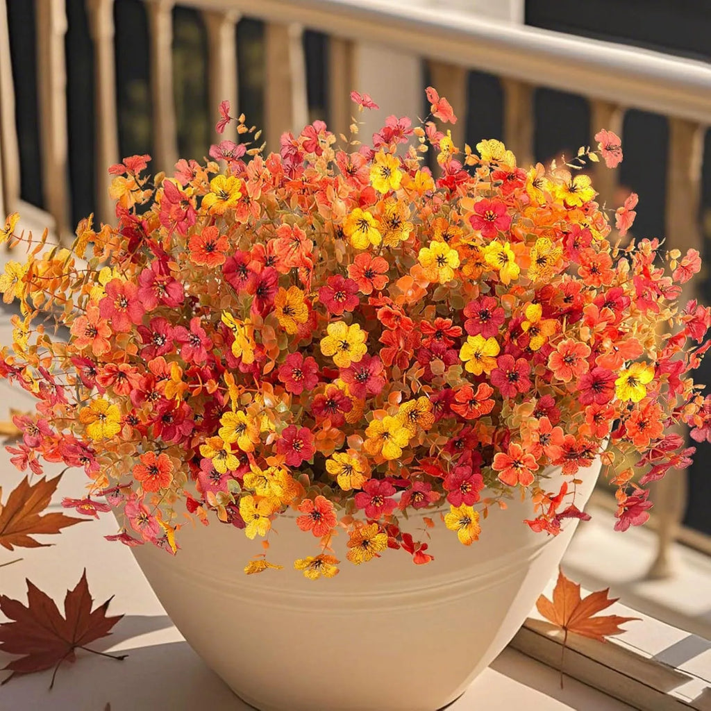 Artificial flower bouquet in autumn orange, red, and yellow colours for home or wedding decoration.