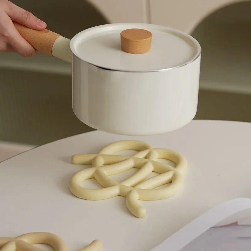 Ceramic heat proof mat in irregular shape on a wooden table