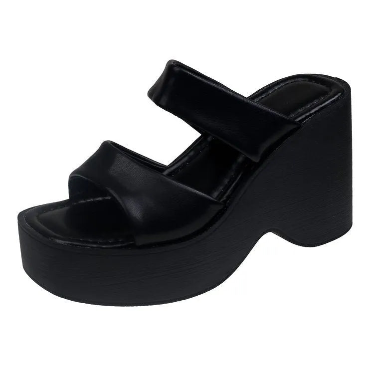 Women's black wedge platform slippers with a square toe on a plain background.