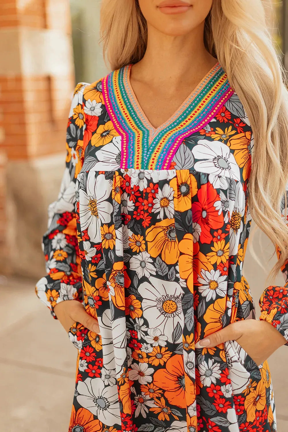 Orange floral print mini dress with V-neck, long sleeves, and striped lace detailing