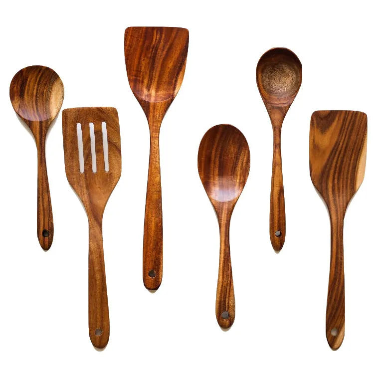 Seven wooden cooking spoons and spatulas with non-slip handles arranged as a set for non-stick pans.