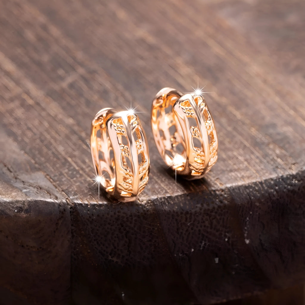 Rose gold copper earrings with hollowed-out heart and leaf designs on white background
