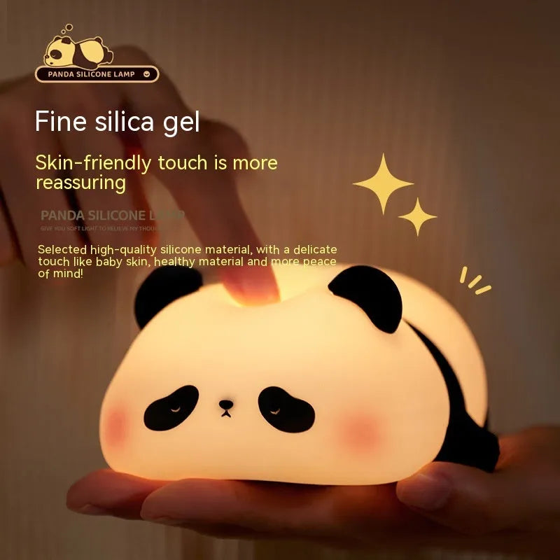 Cute cartoon panda-shaped silicone night light for children on a bedside table.