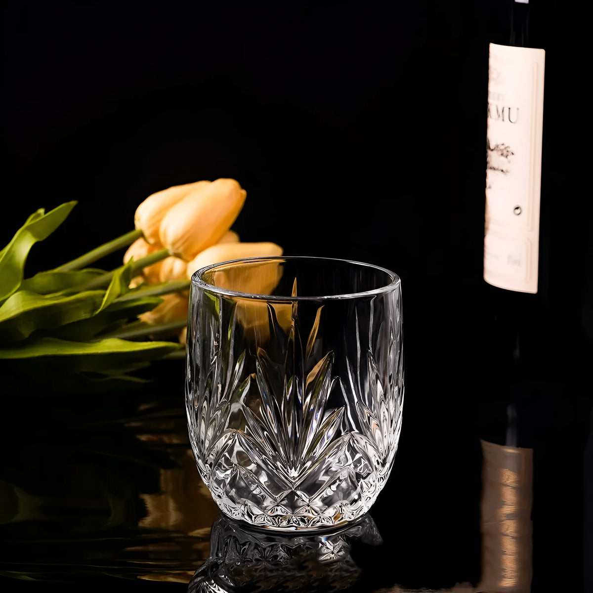 Clear crystal whiskey shot glass with a thick bottom base on a table.