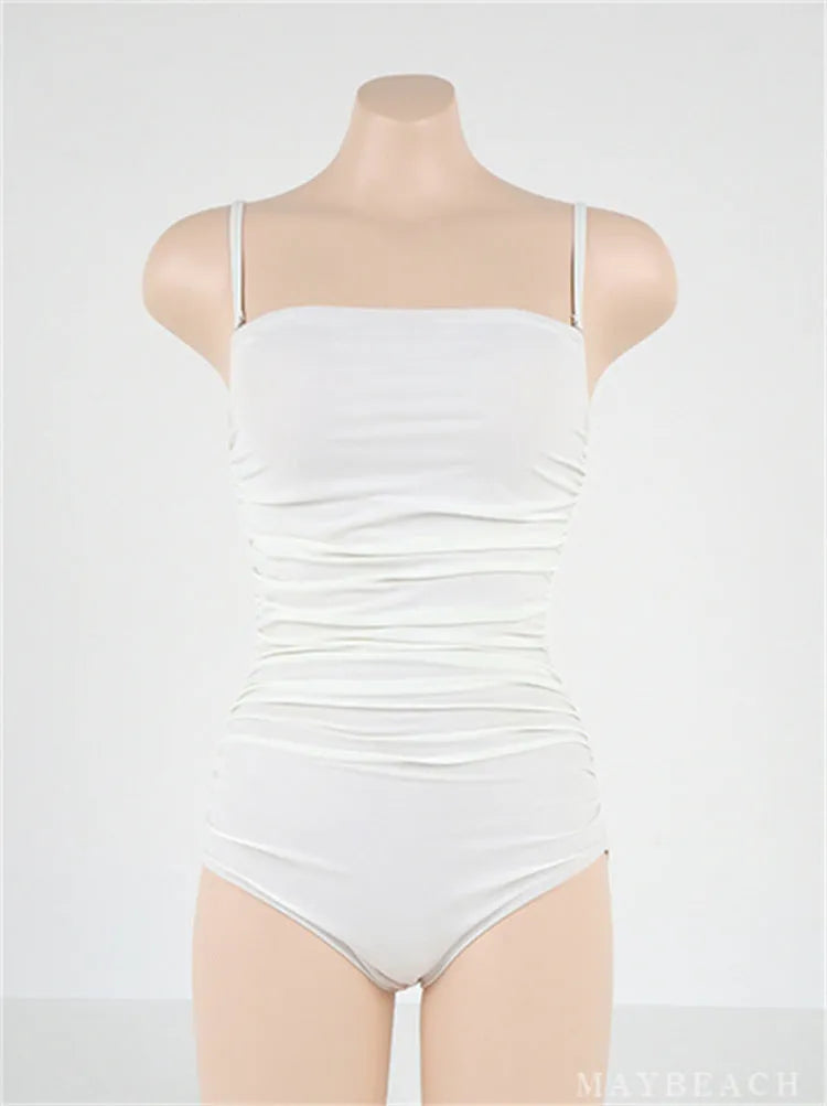 Sling style belly pleated one-piece swimsuit in solid colour on a mannequin.