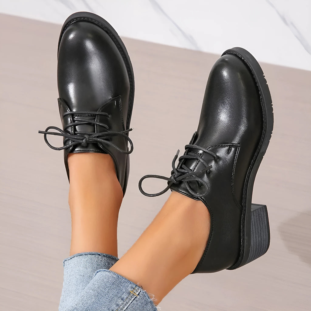 Black women's low-top work shoes with a chunky heel and pointed toe.