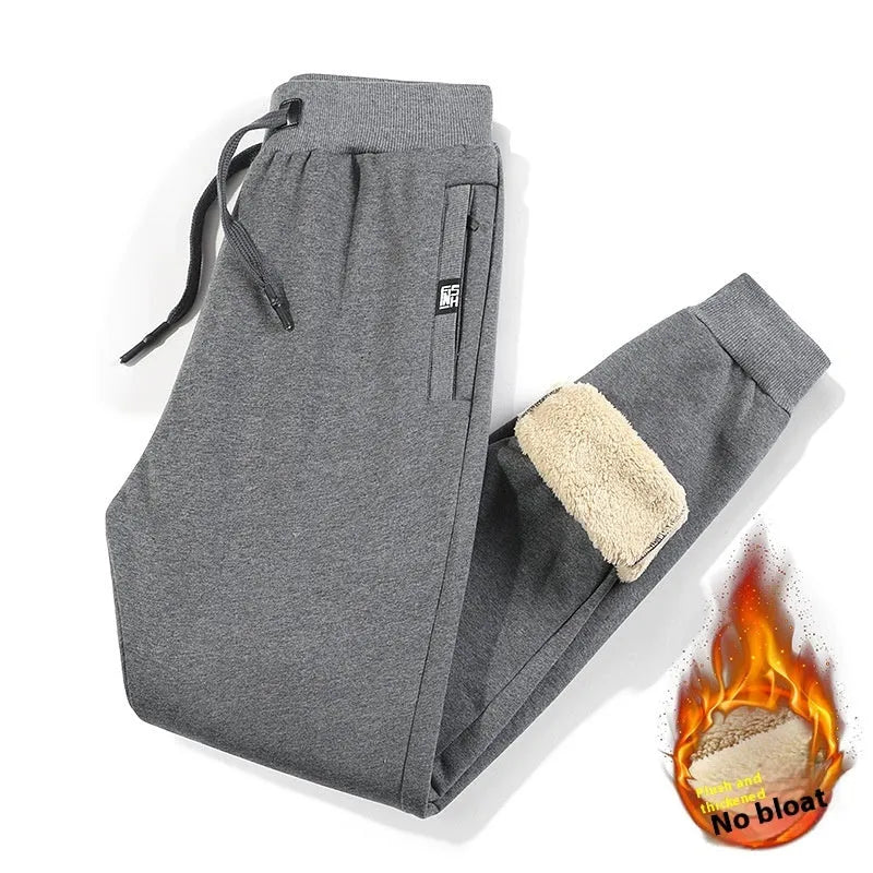 Men's grey fleece-lined oversized track pants with elastic waistband on hanger
