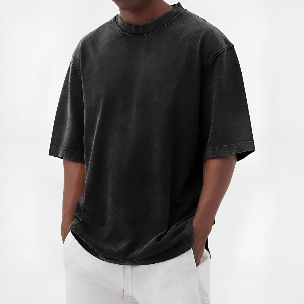 A man's loose-fit, stone-washed pullover t-shirt in a solid colour, shown on a hanger.