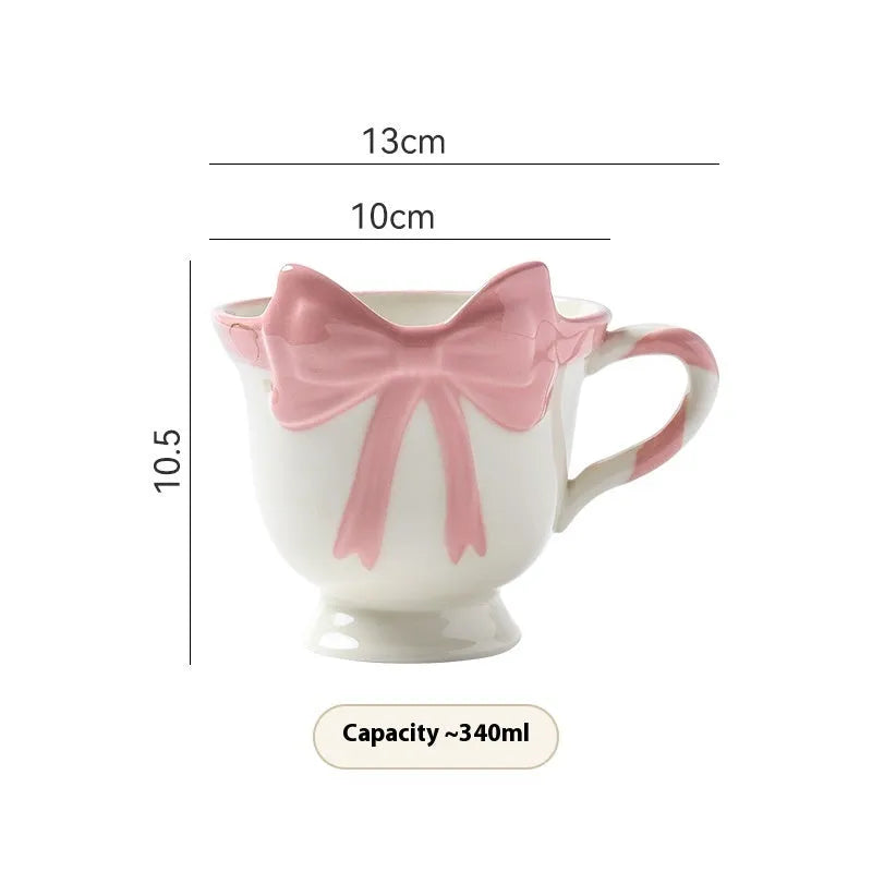 Ceramic mug with heart and bow design in white or black pink colours