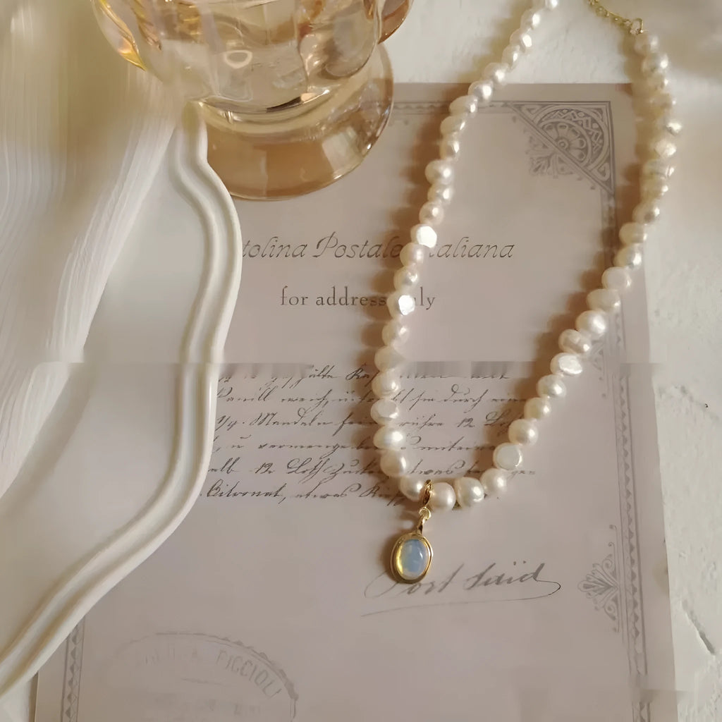 Vintage pearl necklace with geometric pendant on adjustable chain.