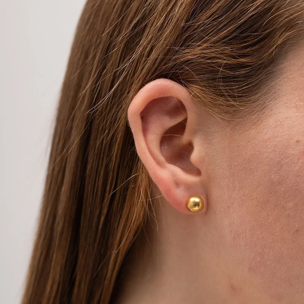 Stainless steel ball stud earrings with geometric design in gold or silver finish.