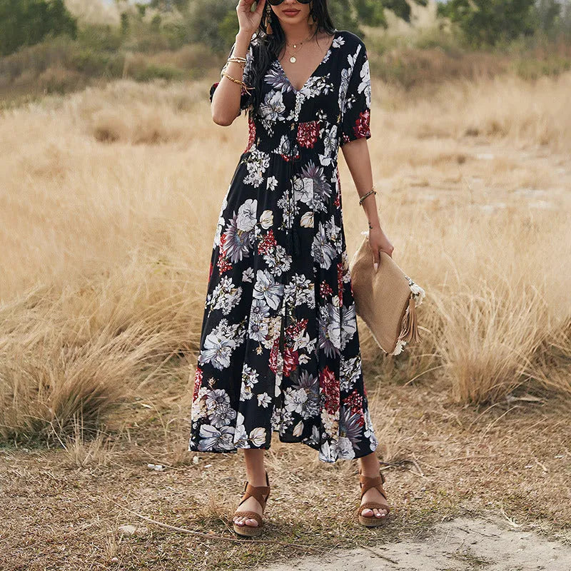 Yellow floral print women's dress with V-neck, short sleeves, elastic high waist, and flowing mid-length skirt.