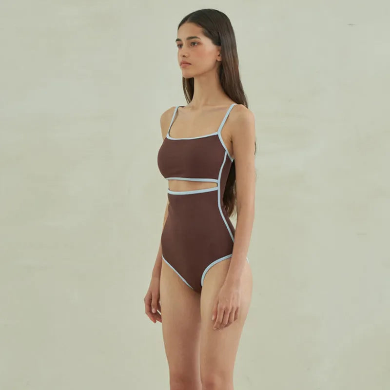 Brown women's one-piece swimsuit with triangle neckline on a hanger.