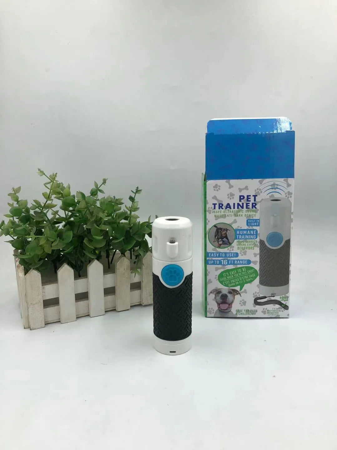 White handheld ultrasonic dog bark control device on plain background