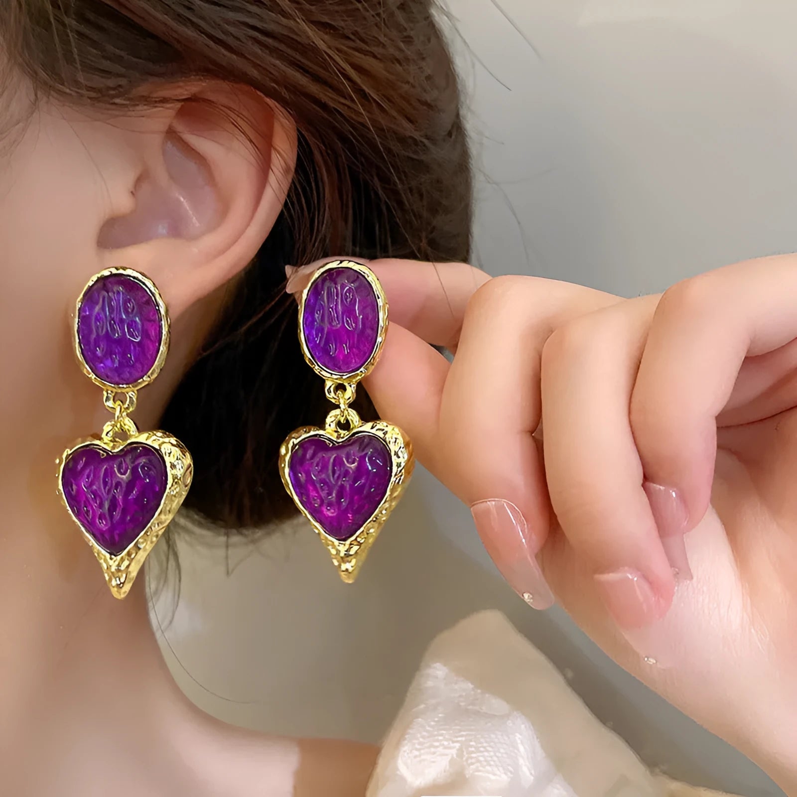 Four pairs of oval love heart stud earrings with silver needle pleated detailing in purple, red, green, and yellow-white colours
