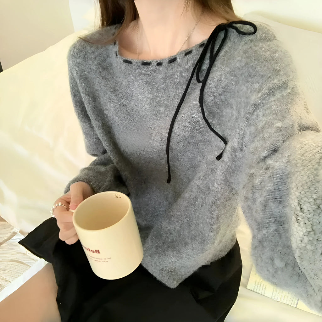 Women's loose-fitting black knitwear pullover jumper on a hanger.