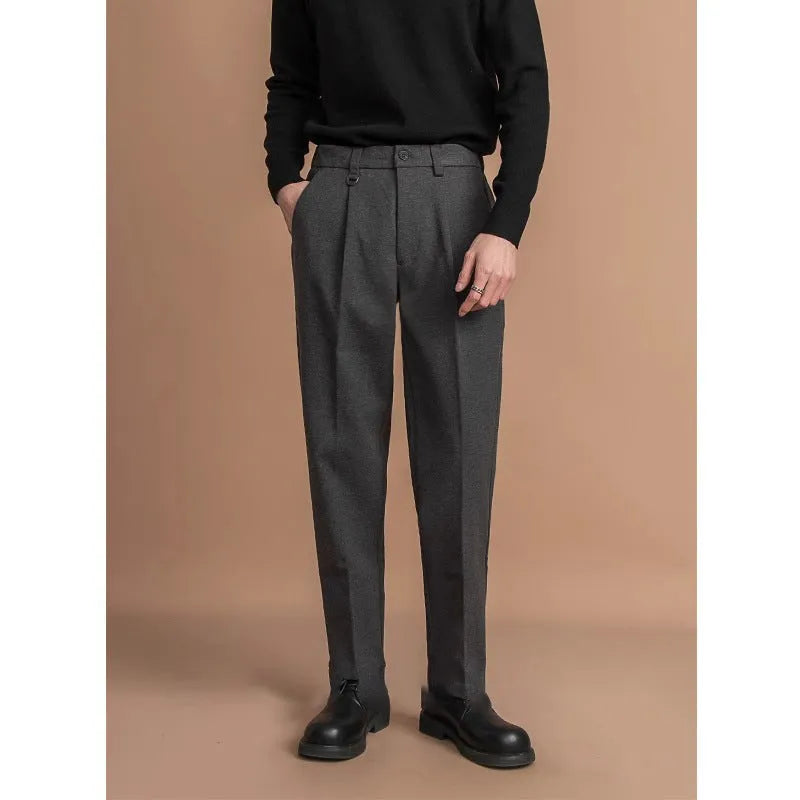 Men's straight-leg casual trousers in black, shown in a light business style setting.