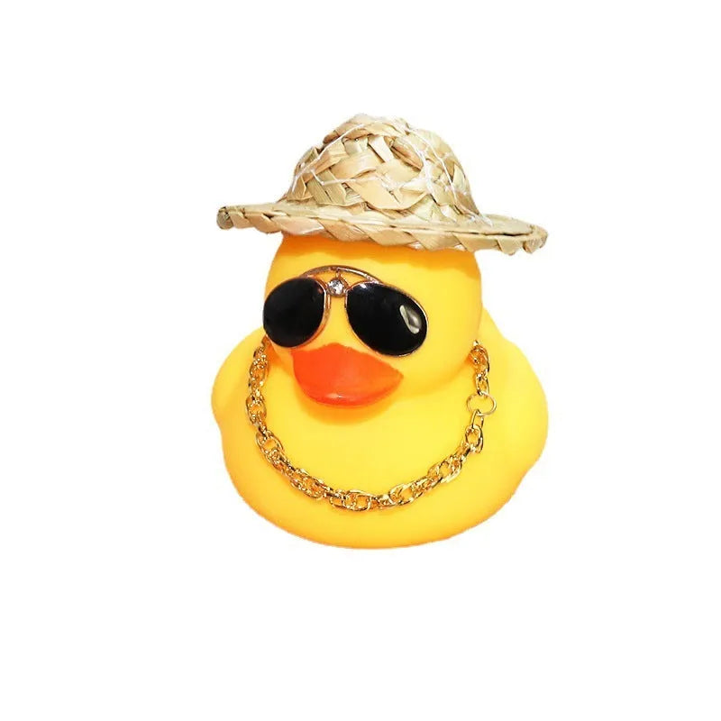 Yellow duck car ornament wearing straw hat with removable sunglasses necklace on dashboard