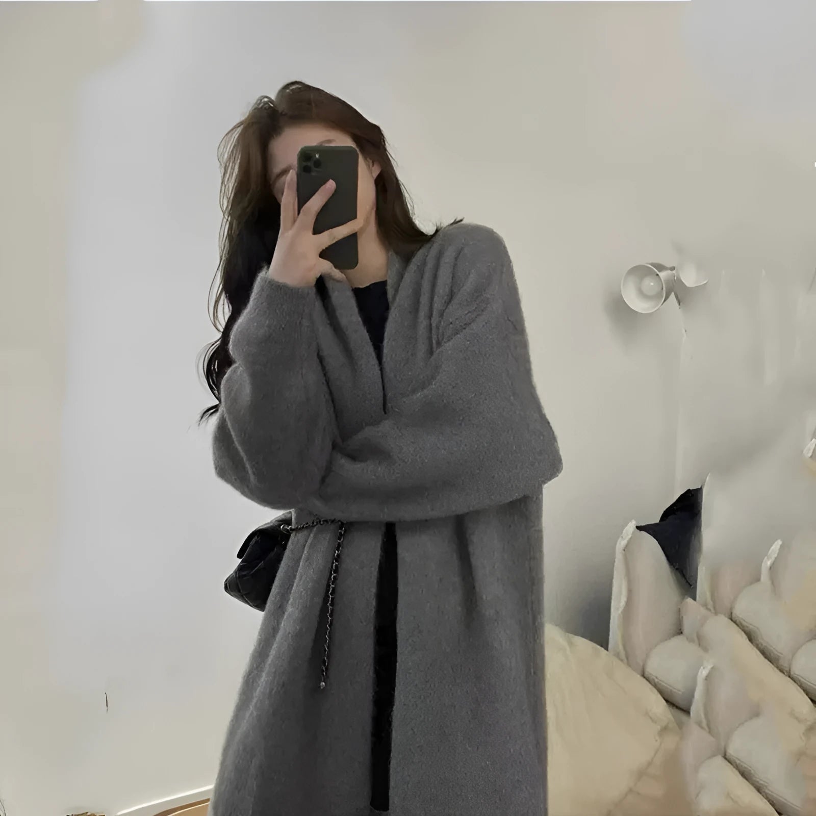 Women's loose black chenille cardigan with a 3D pattern and long sleeves on a hanger.