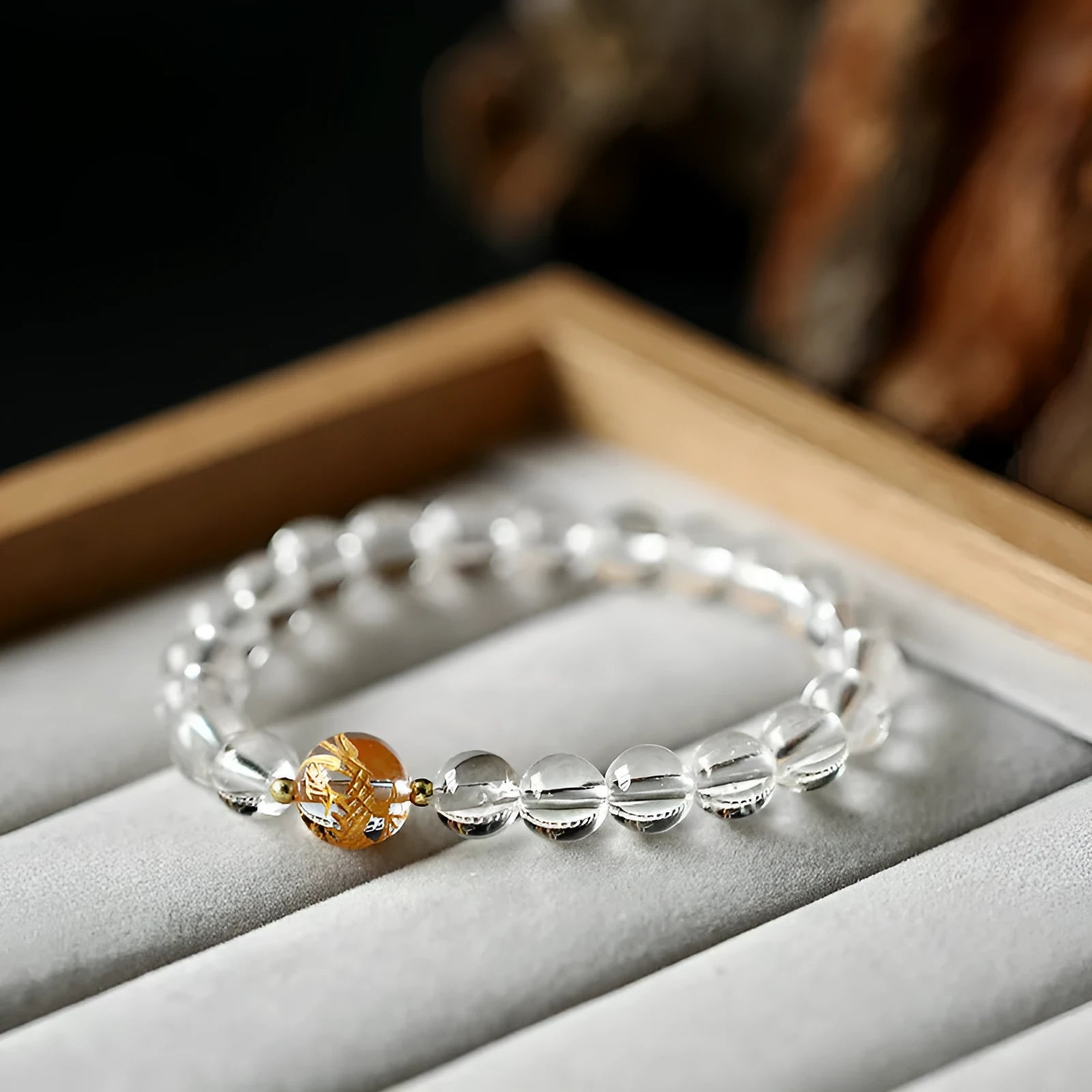 Geometric obsidian and white crystal unisex bracelet with a golden dragon bead on a wrist.