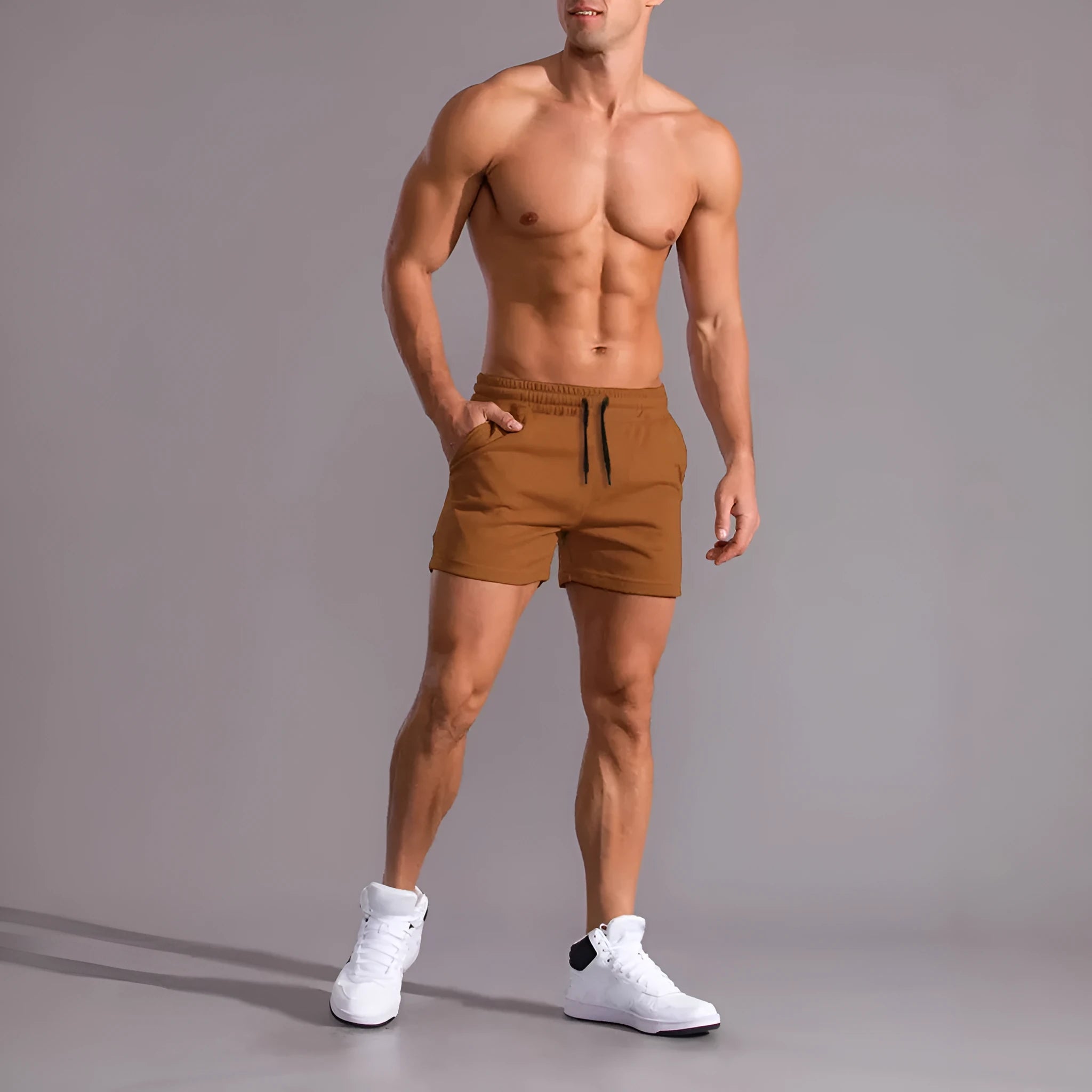 Three pairs of men's solid colour elastic shorts in black, khaki and light brown on a white background