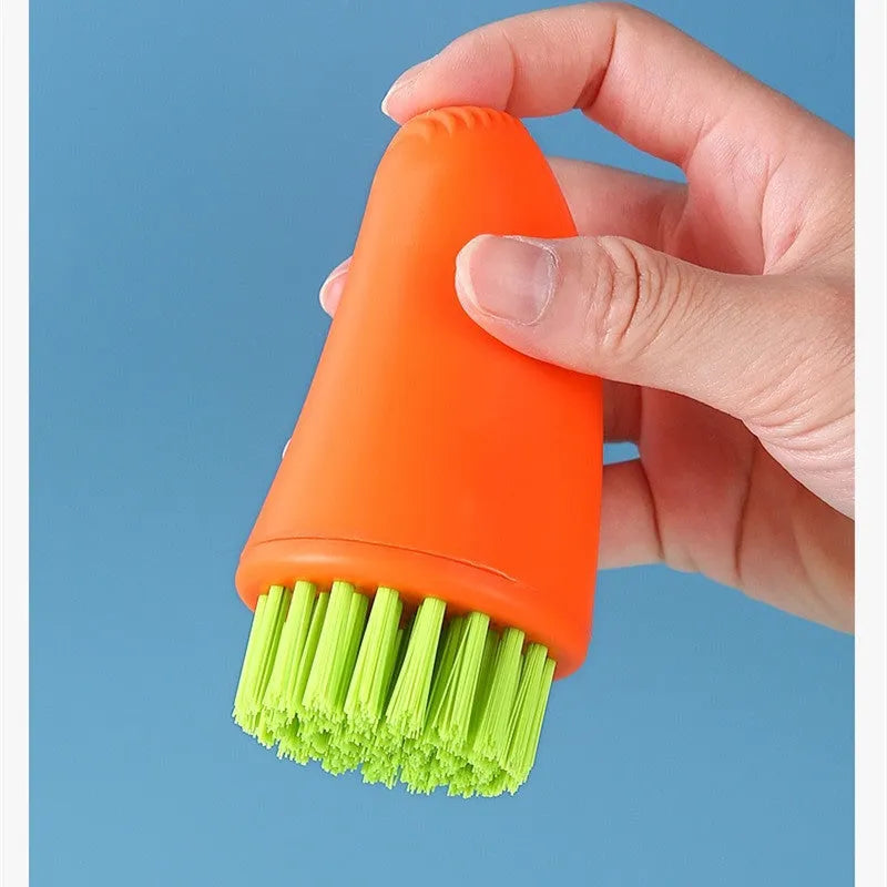 Carrot-shaped nylon kitchen cleaning brush on a white background, shown in orange and white colour options.