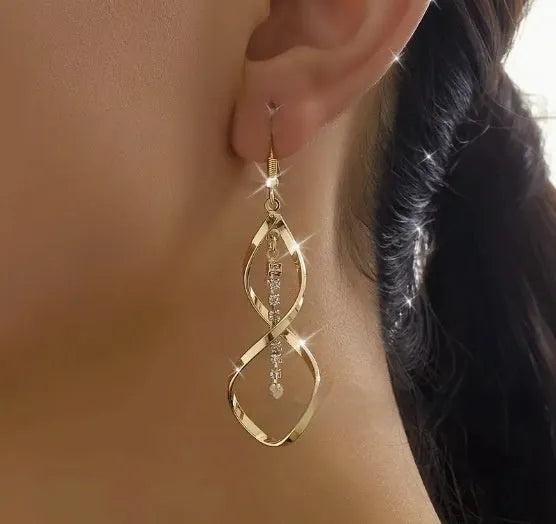 Women's gold geometric spiral earrings with ellipse diamond elements on alloy construction