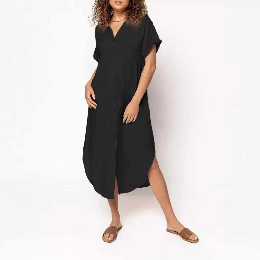A woman wearing a loose-fitting, mid-length apricot-coloured casual dress with a button-down front.
