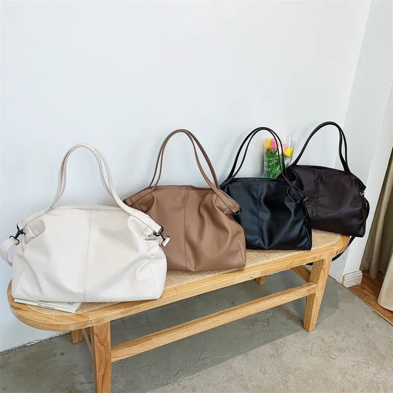 Large soft surface PU messenger bag in horizontal square shape with zip opening and shoulder strap.